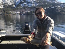 Emily Johnson holding a fish while sitting in a boat.